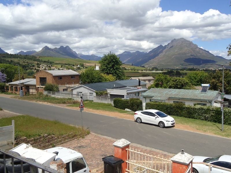 Elevated view overlooking a residential street with scenic mountain vistas in the background.