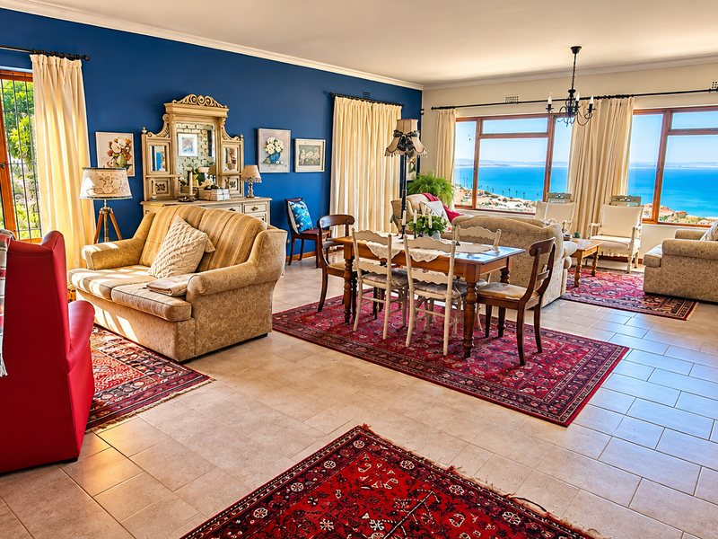 Spacious open-plan living and dining area featuring tiled floors, large windows with scenic ocean views, and a bright, airy atmosphere.