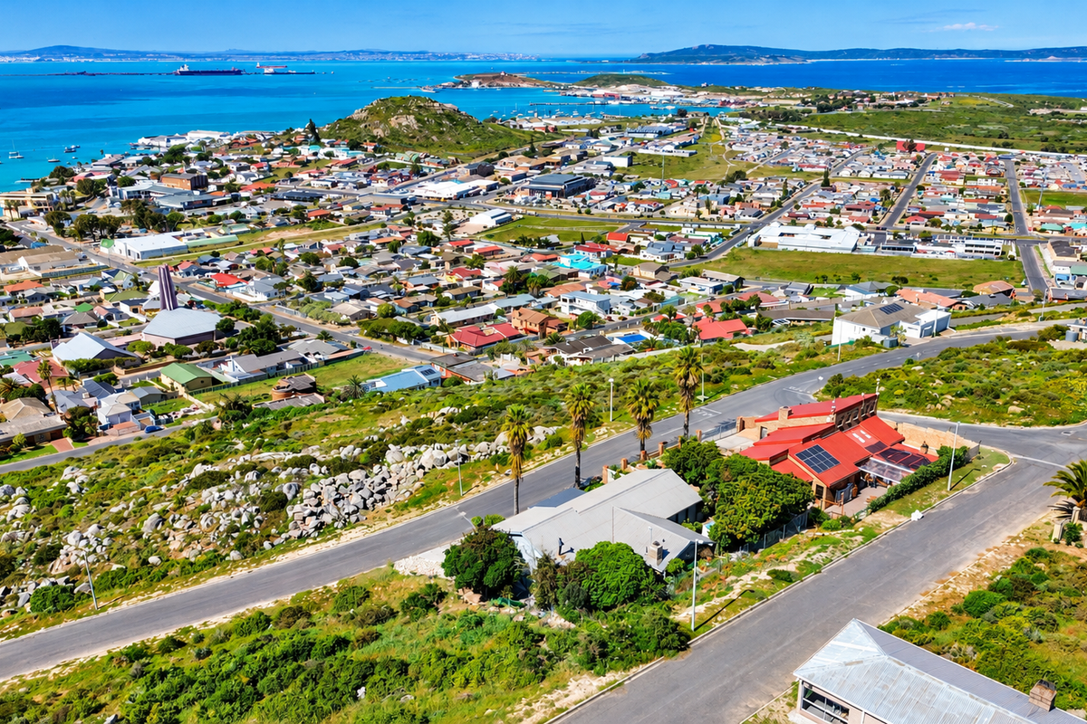 An elevated aerial view of the property showcasing its location, surrounding neighbourhood, and coastal landscape.