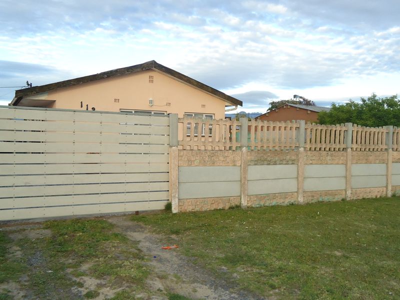 Front view of a single-story house featuring a horizontal slat gate and a precast concrete boundary wall.