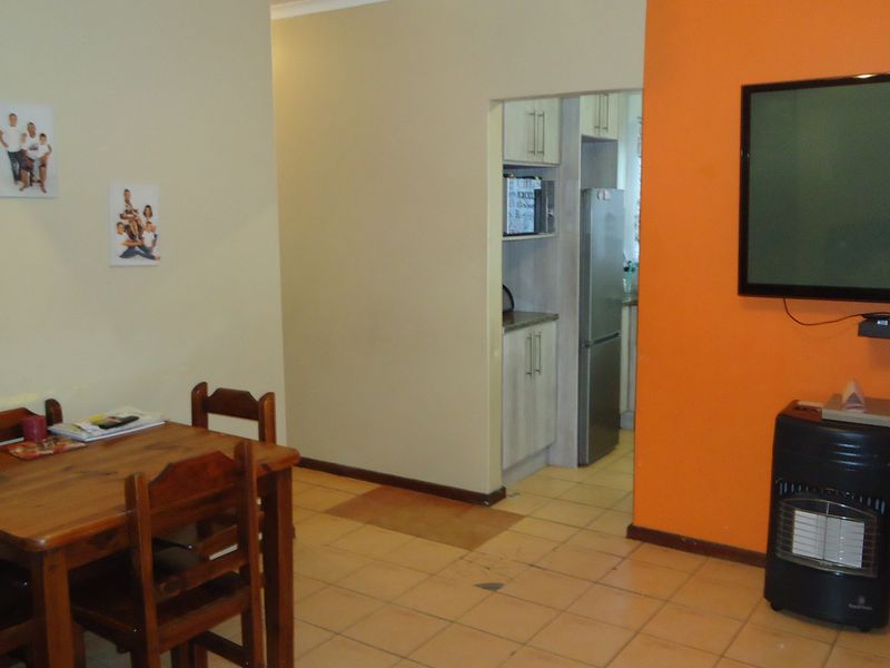 Open plan living and dining area featuring tiled flooring and a view into the adjacent kitchen space.
