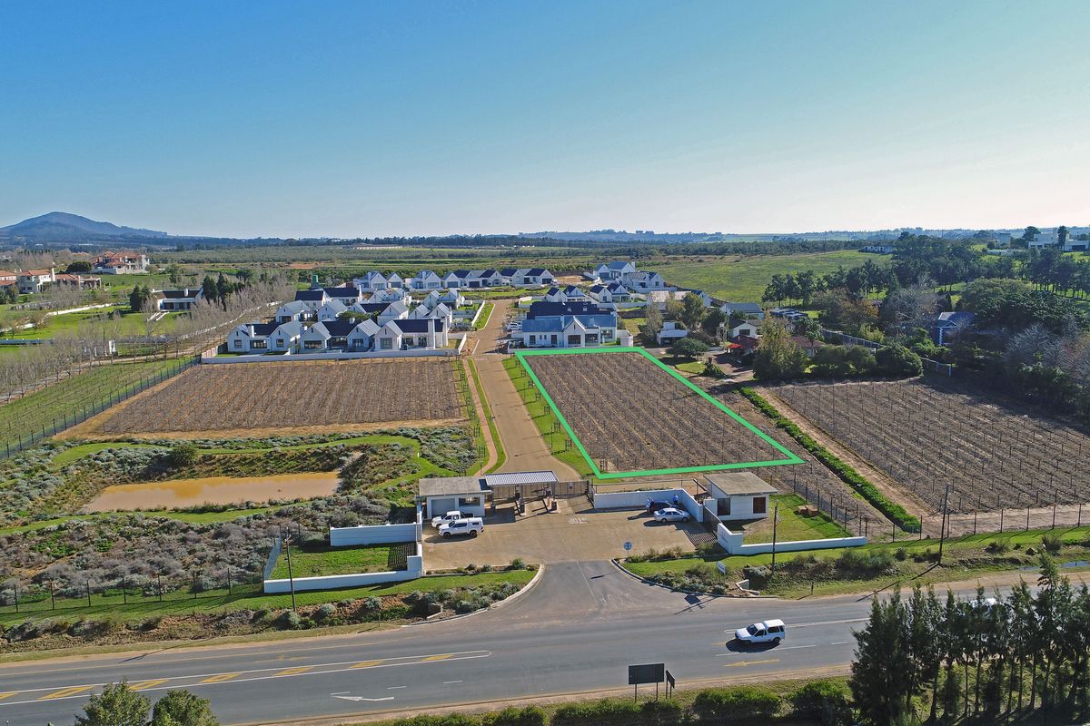 Aerial view of a vacant residential plot within a secure estate, featuring clear boundary demarcation and access to established infrastructure.