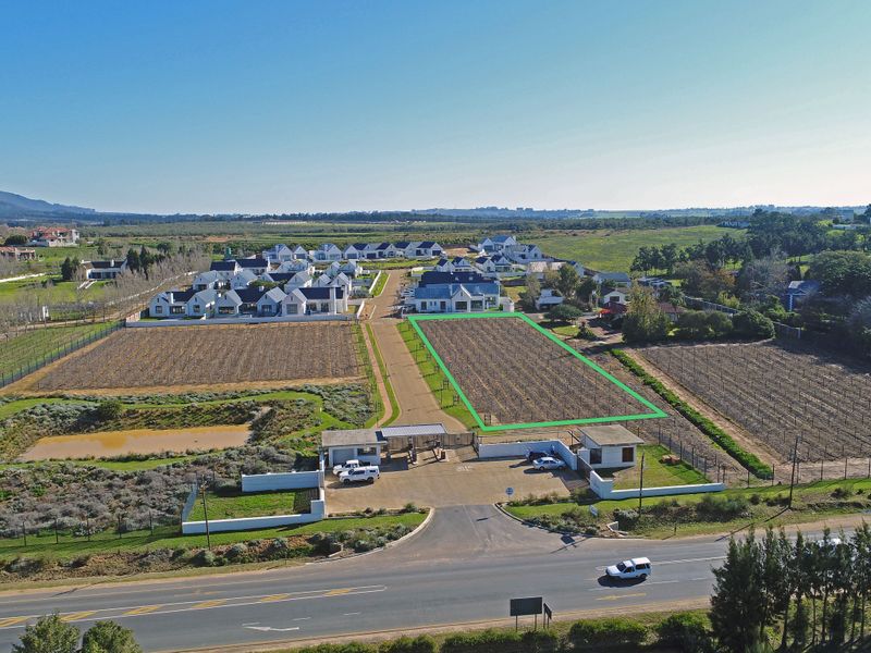 Aerial view of a vacant residential plot within a secure estate, featuring clear boundary demarcation and access to established infrastructure.