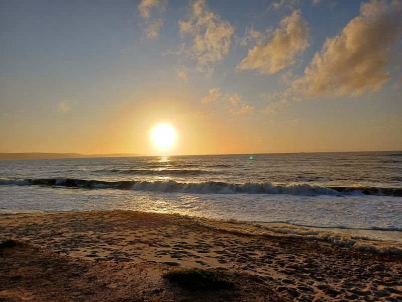 A scenic view of the ocean at sunset, showcasing the natural landscape and coastal frontage of the property.