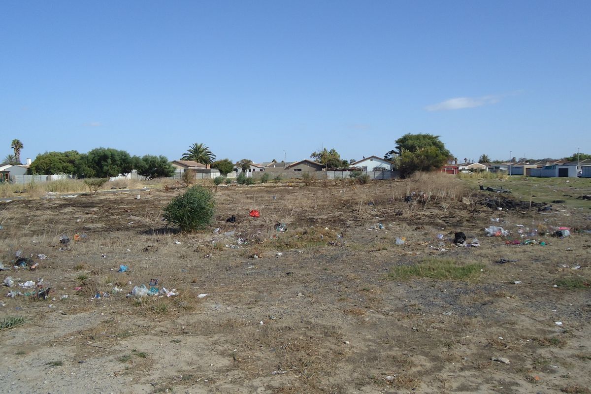 A vacant residential plot of land requiring clearing and site preparation, situated in an established suburban neighborhood.