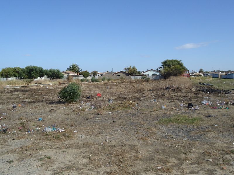 A vacant residential plot of land requiring clearing and site preparation, situated in an established suburban neighborhood.