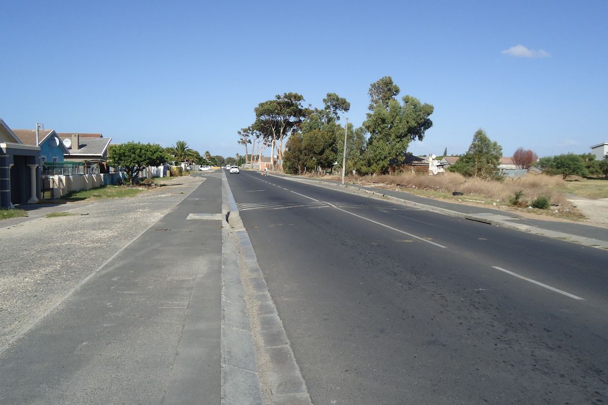 A street view showing the paved road, sidewalk, and curb infrastructure adjacent to the residential property.