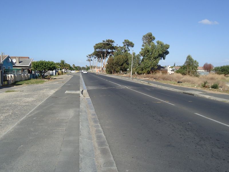A street view showing the paved road, sidewalk, and curb infrastructure adjacent to the residential property.