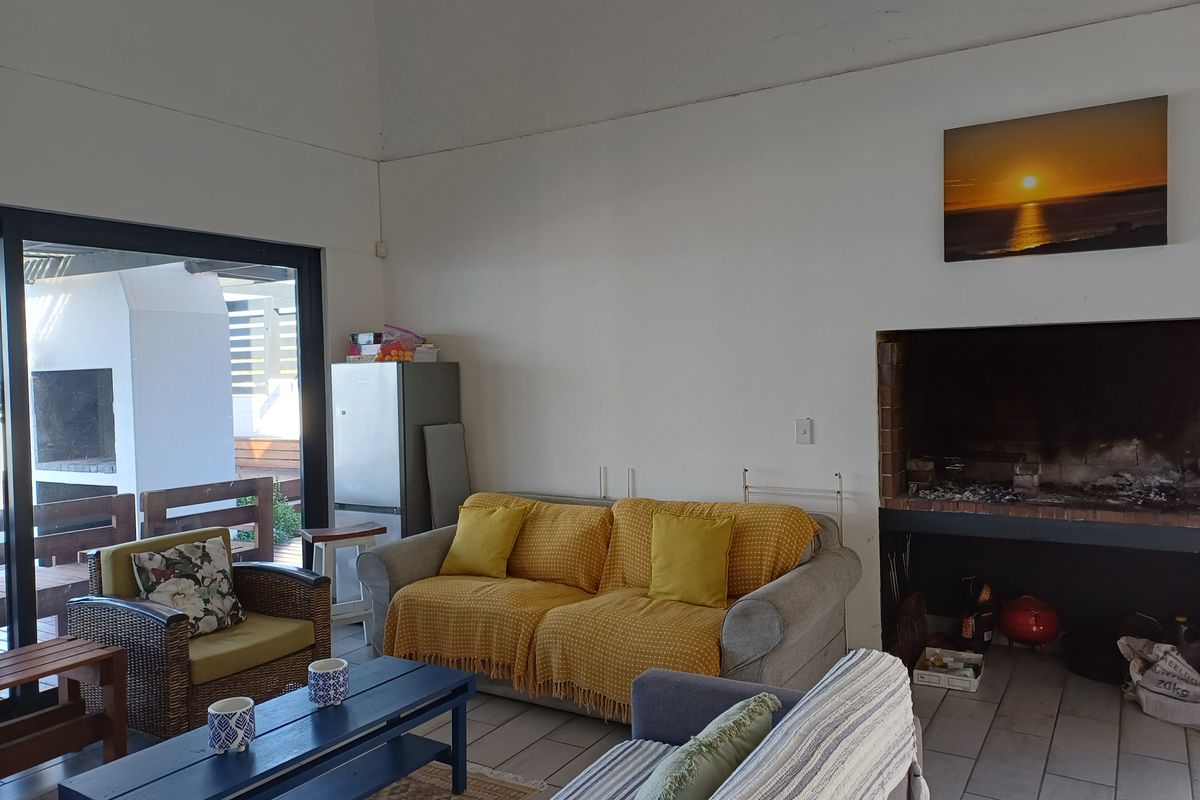 Spacious living room featuring a built-in fireplace, vaulted ceilings, and large sliding glass doors providing seamless access to the outdoor patio area.