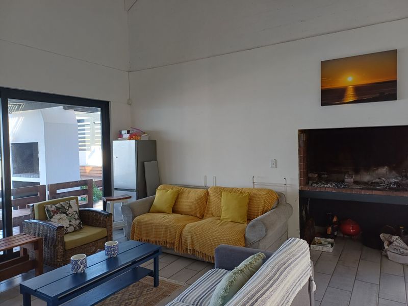 Spacious living room featuring a built-in fireplace, vaulted ceilings, and large sliding glass doors providing seamless access to the outdoor patio area.