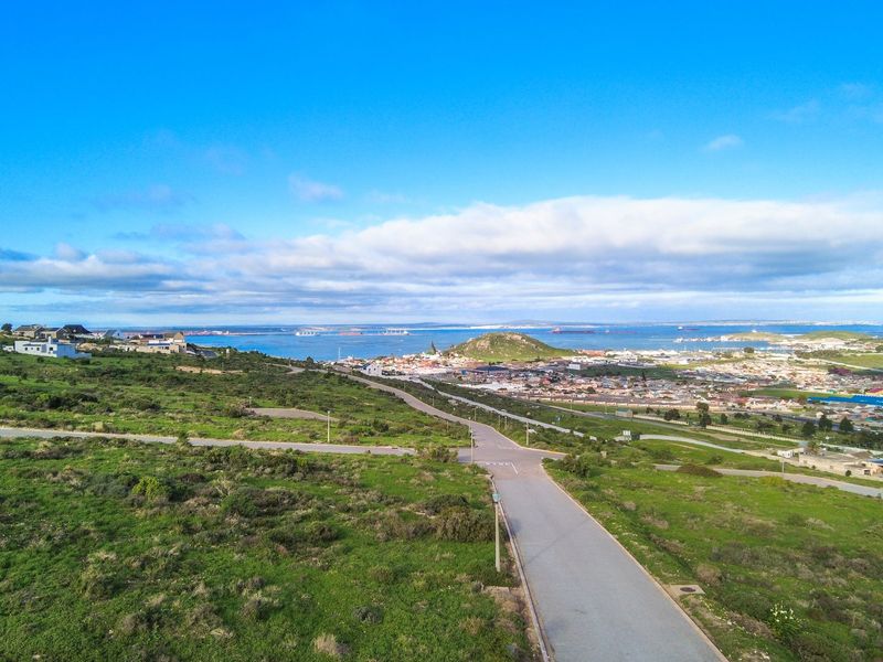 An elevated aerial view showcasing the surrounding landscape, coastal proximity, and local road infrastructure.