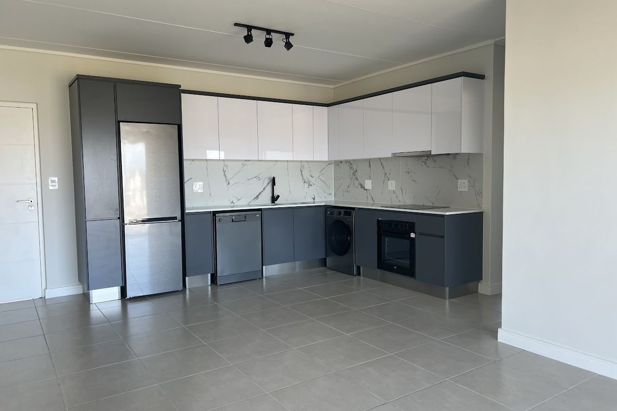 Modern kitchen featuring sleek two-tone cabinetry, marble-look splashback, integrated oven, cooktop, and tiled flooring in an open-plan layout.