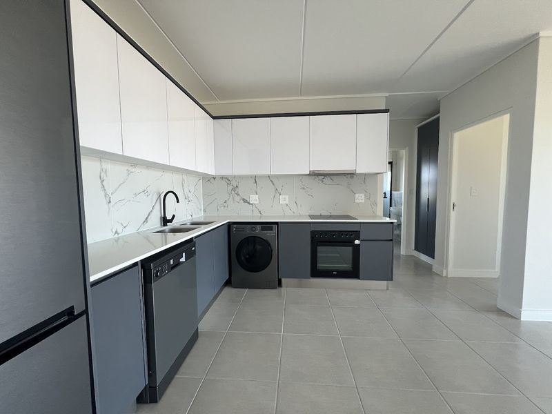 Modern kitchen featuring sleek two-tone cabinetry, marble-look splashbacks, integrated appliances, and high-quality tiled flooring in a clean, contemporary layout.