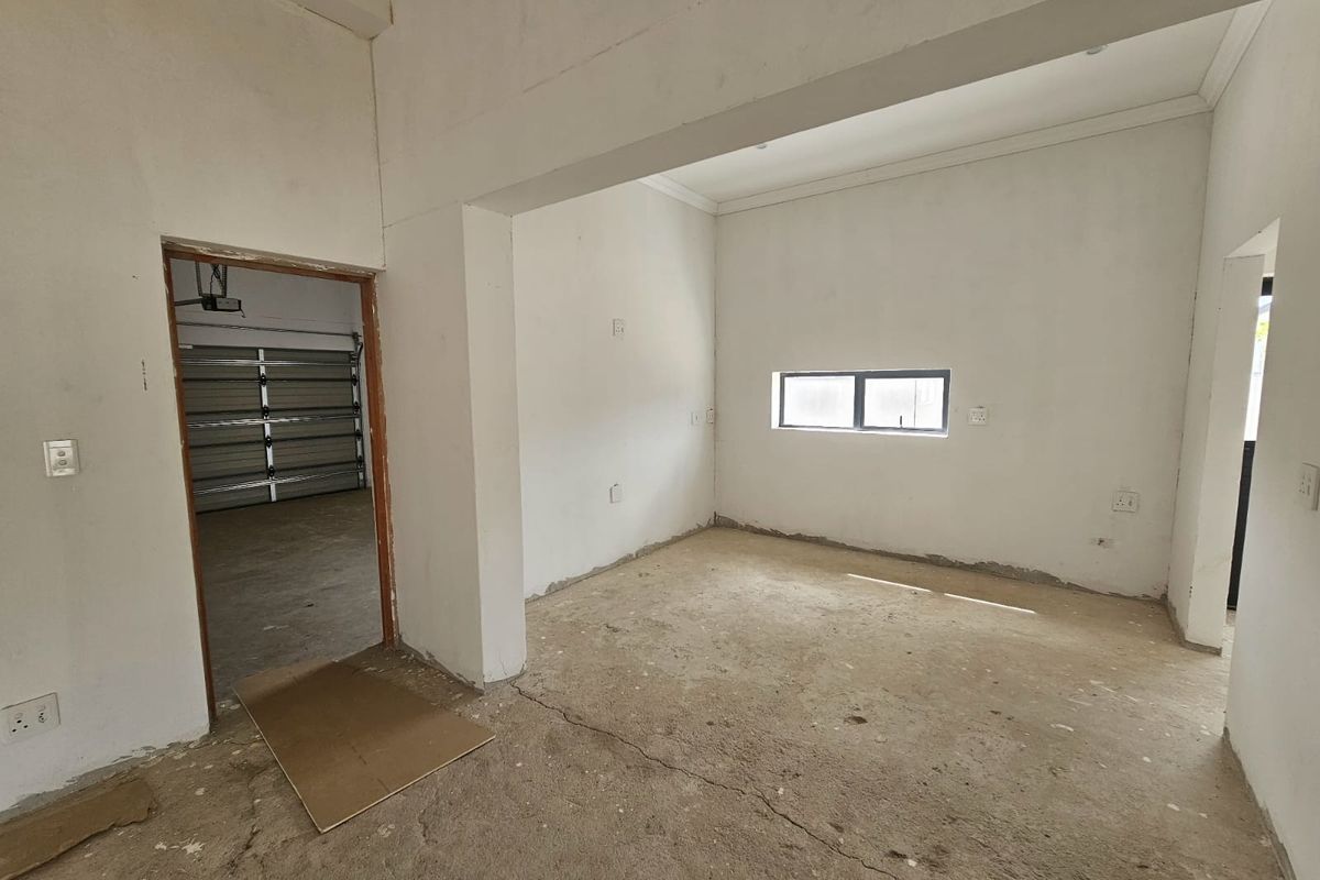 An unfinished interior space featuring raw concrete flooring and direct access to a garage, offering a blank canvas for renovation and interior design.