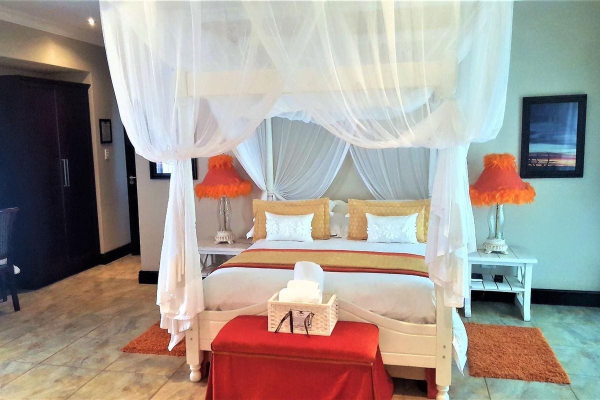A spacious bedroom featuring tiled flooring, neutral wall finishes, and a built-in wardrobe, creating a comfortable and well-maintained living space.