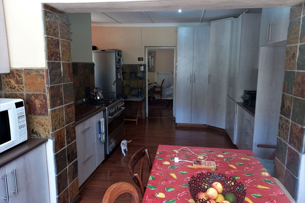 A functional kitchen featuring built-in cabinetry, a gas stove, and a stone-tiled feature wall, providing a practical layout for daily meal preparation.