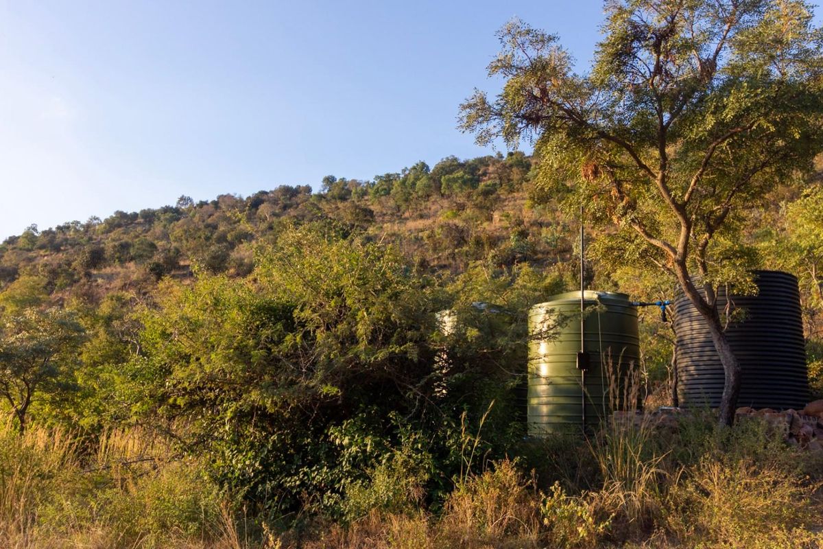 A view of the natural landscape featuring two large water storage tanks positioned on the property.