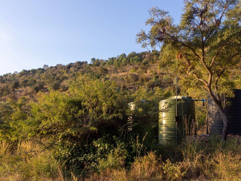 A view of the natural landscape featuring two large water storage tanks positioned on the property.