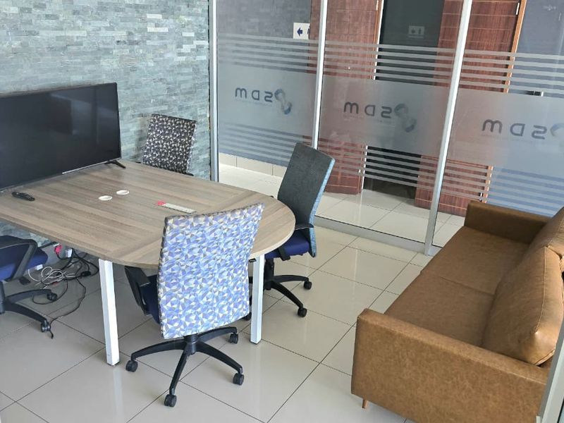 A modern office space featuring a stone veneer accent wall, glass partition walls, and polished tile flooring, suitable for professional meetings.