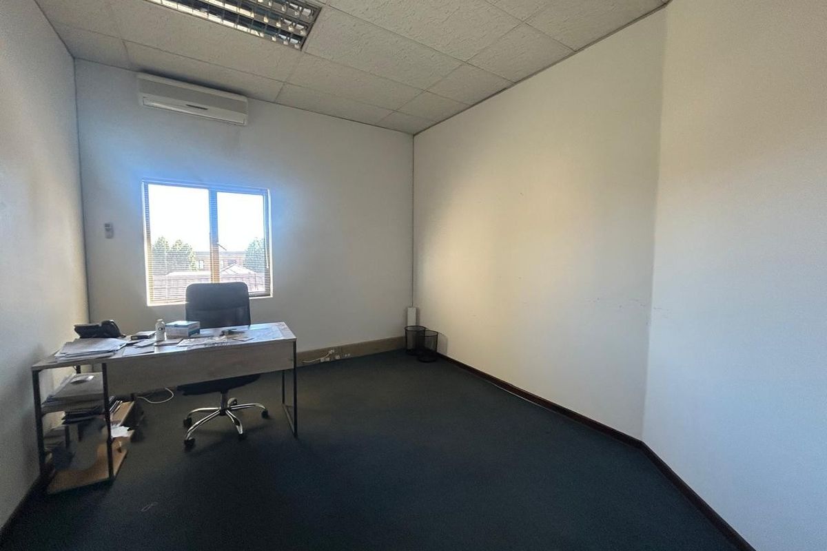 A functional office space featuring a suspended ceiling, split-system air conditioning, and carpeted flooring, providing a practical environment for professional use.