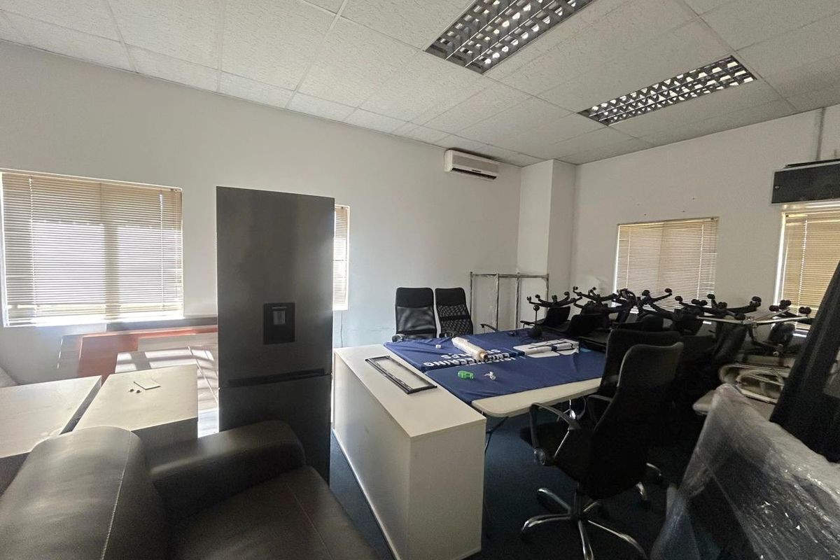 A functional office space featuring a suspended ceiling with recessed lighting, split-system air conditioning, and multiple windows fitted with venetian blinds.