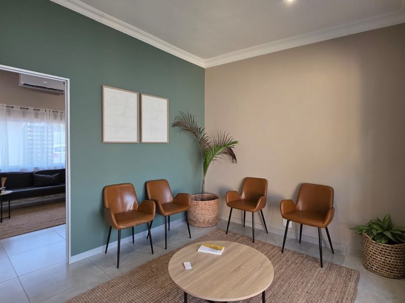 A well-maintained office waiting area featuring dual-tone painted walls, crown molding, and tiled flooring, providing a professional and welcoming atmosphere.