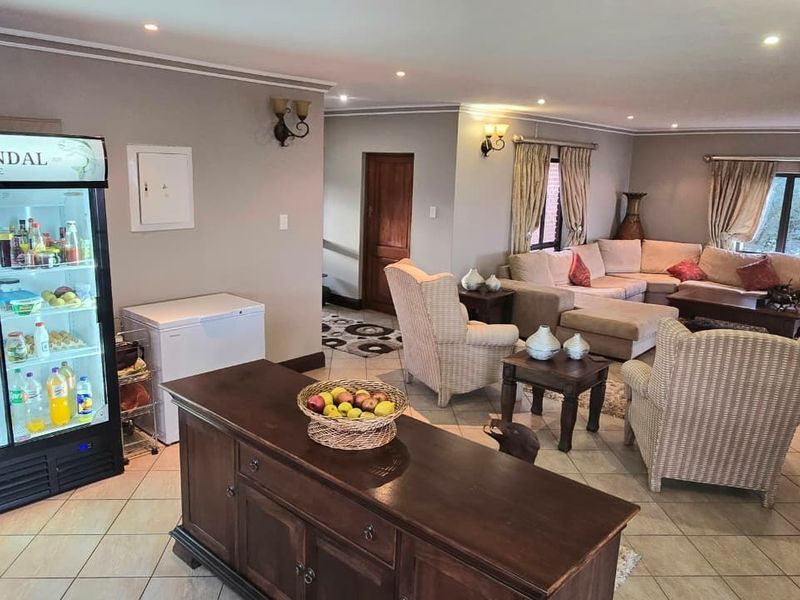 Spacious open-plan living area featuring tiled flooring, recessed lighting, and neutral wall tones, providing a comfortable and functional communal space.