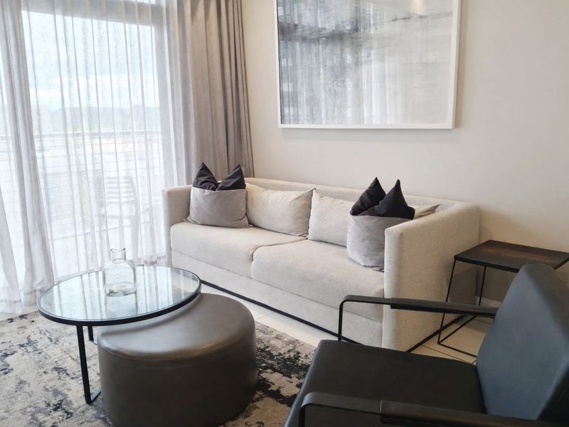 A modern living room featuring tiled flooring and a large sliding glass door that provides access to an outdoor area.