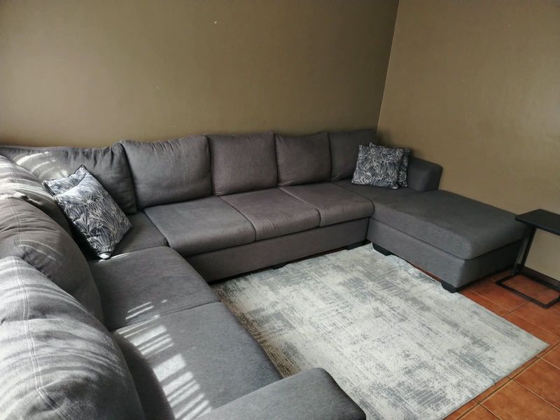 A living room area featuring tiled flooring and neutral wall paint, providing a functional space for relaxation.