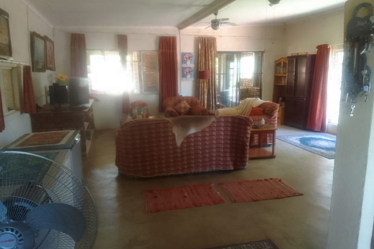 Spacious living area featuring ceiling fans, large windows, and sliding glass doors leading to the exterior.