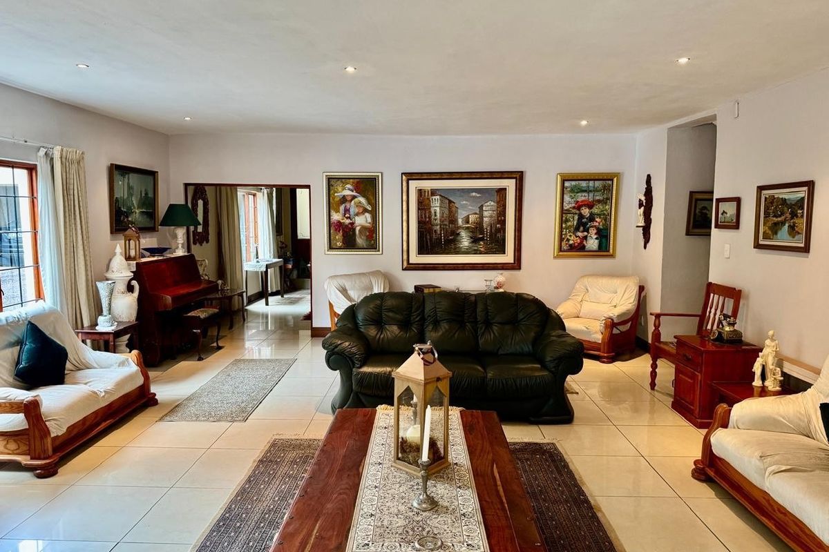 Spacious living room featuring neutral tiled flooring and recessed downlighting, offering a bright and open layout suitable for comfortable family living.