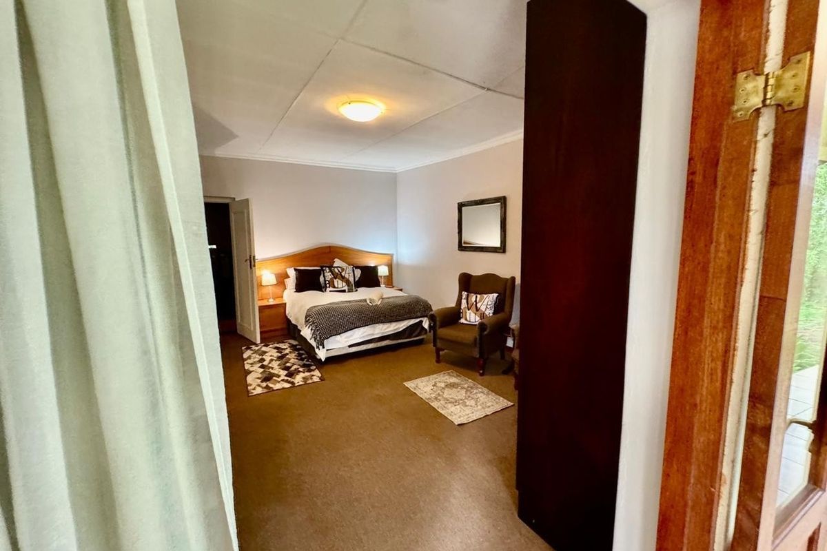 A bedroom featuring a built-in headboard and neutral wall finishes, requiring updates to flooring and ceiling fixtures to improve overall condition.