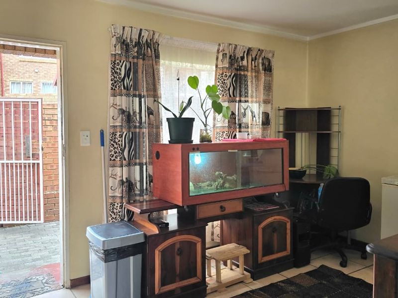 An entry area featuring tiled flooring and direct access to an exterior paved courtyard with a security gate.