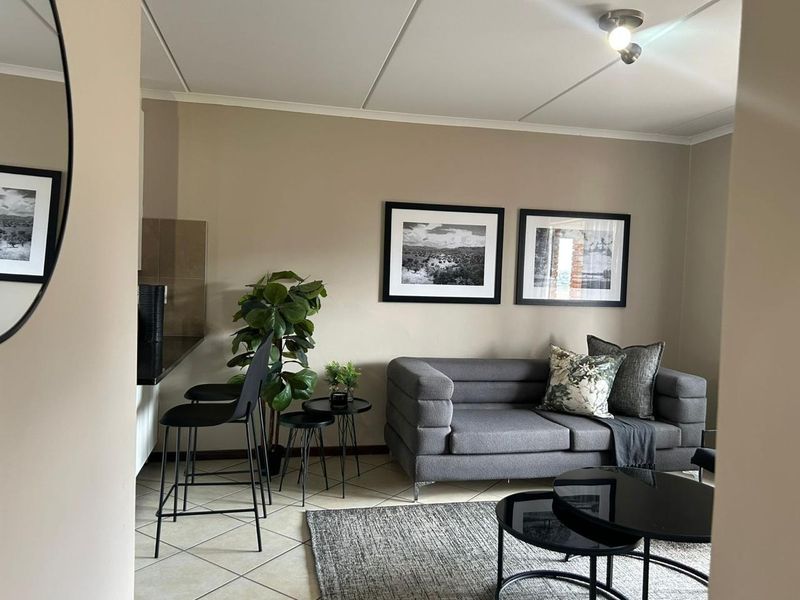 An open-plan living area featuring tiled flooring and a compact kitchen counter, creating a functional and well-maintained space.