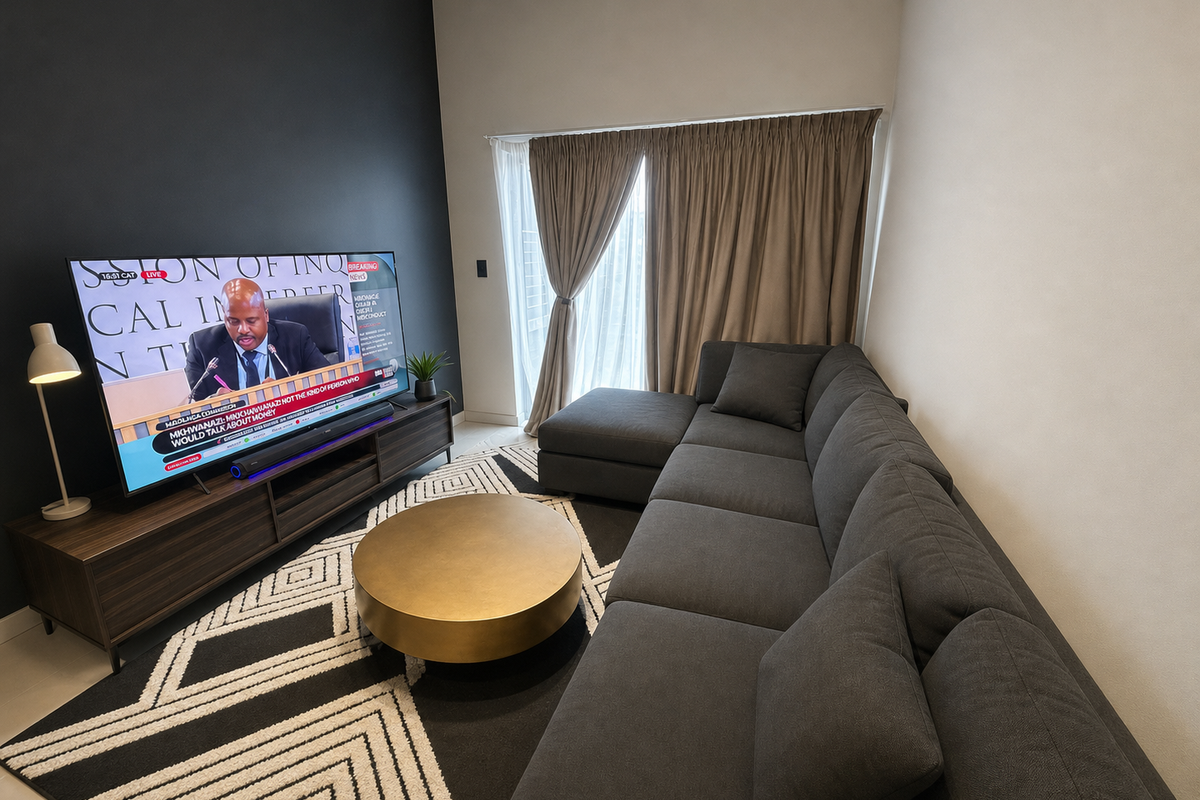 A modern living room featuring a dark accent wall, neutral flooring, and a large sliding glass door with integrated curtain tracks.