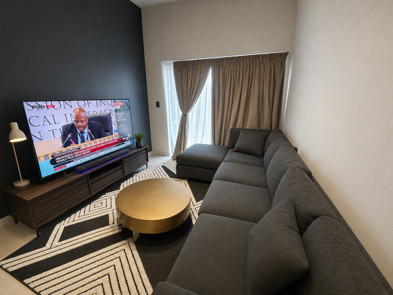 A modern living room featuring a dark accent wall, neutral flooring, and a large sliding glass door with integrated curtain tracks.