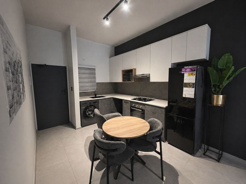 Modern kitchen featuring sleek two-tone cabinetry, integrated appliances, gas hob, and tiled flooring, offering a contemporary and functional culinary space.