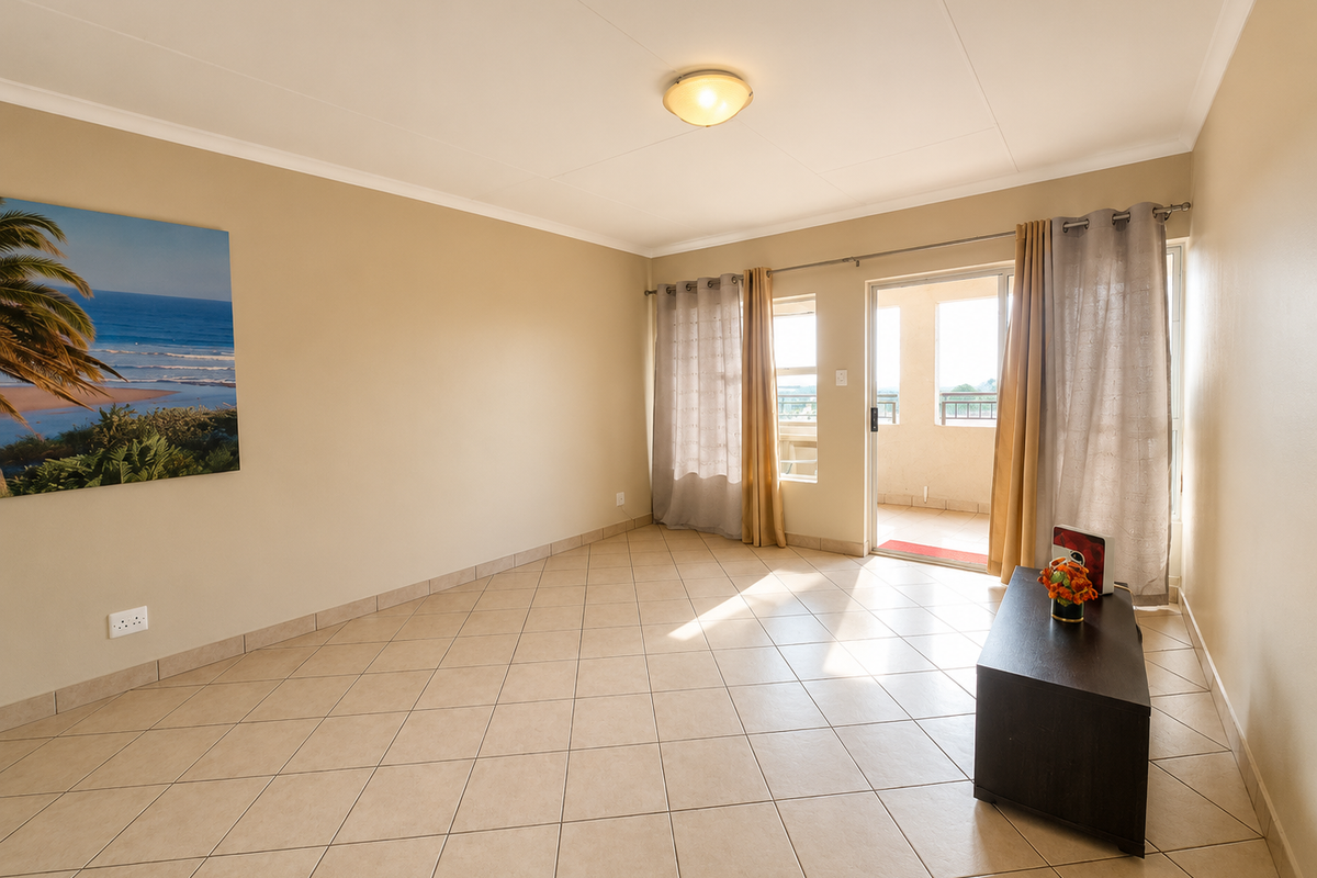 A bright and spacious living area featuring neutral tiled flooring and a sliding glass door that opens onto a private balcony.