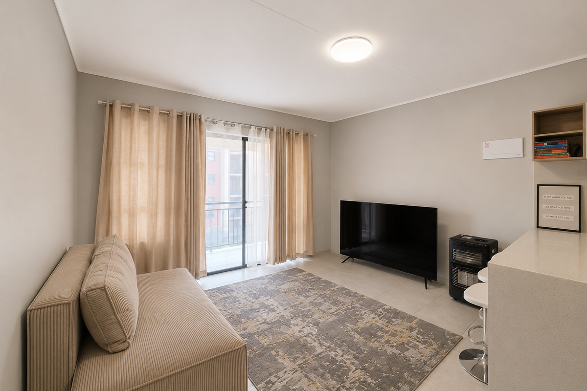 A bright and well-maintained living room featuring tiled flooring, a sliding glass door leading to a balcony, and built-in shelving.