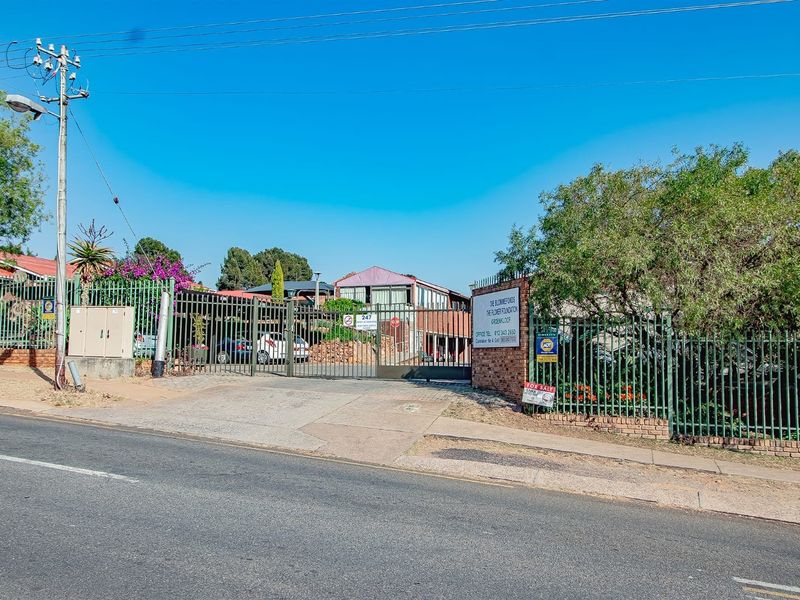 Street view of the property entrance featuring a secure gated access point and paved driveway approach.
