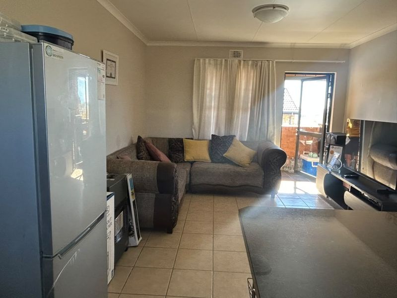 Open plan living area featuring tiled flooring and direct access to an outdoor balcony through a sliding glass door.