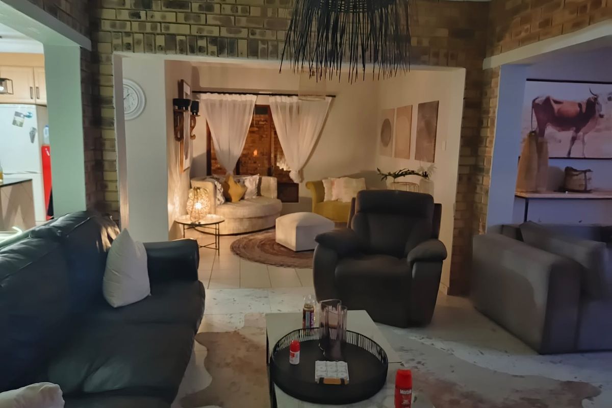 A cozy living room featuring exposed brick walls and a split-level layout, creating distinct zones for relaxation and social interaction.
