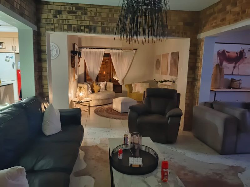 A cozy living room featuring exposed brick walls and a split-level layout, creating distinct zones for relaxation and social interaction.