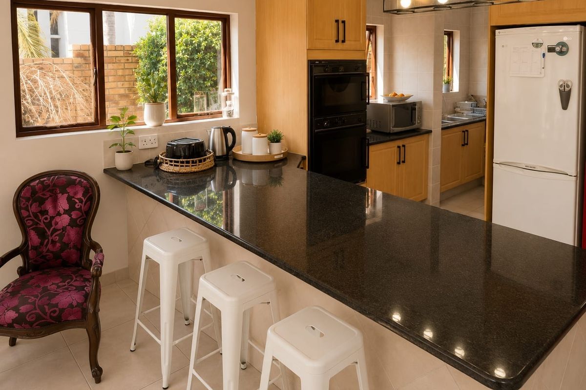 A functional kitchen featuring granite countertops, wooden cabinetry, built-in oven and microwave, and a breakfast bar area with tiled flooring.