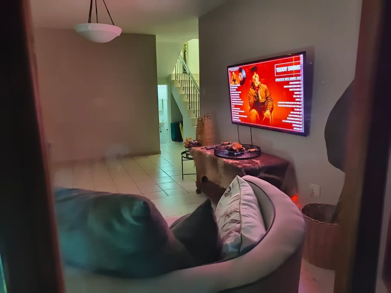 A living room area featuring tiled flooring and an open staircase leading to the upper level.
