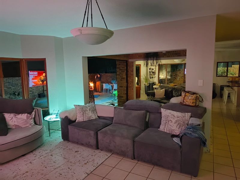 Open plan living area featuring a mix of terrazzo and ceramic tile flooring, exposed brick accents, and seamless flow to an outdoor patio space.