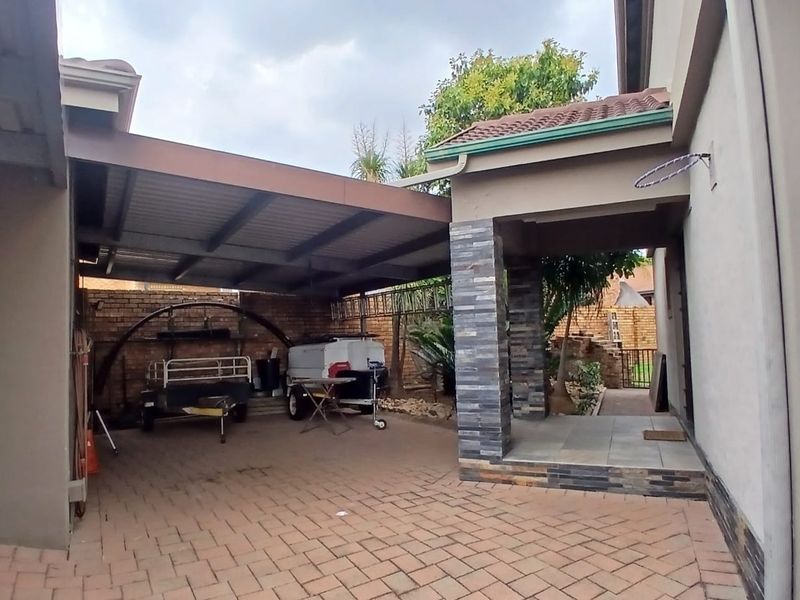 A covered outdoor patio area featuring paved flooring and a stone-clad pillar, providing a functional space for outdoor storage or entertainment.
