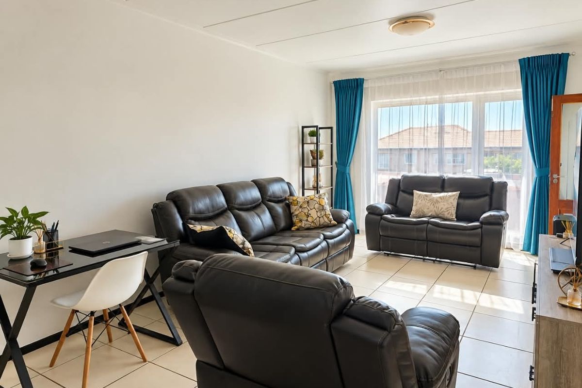 A bright and spacious living room featuring neutral tiled flooring and a large window that allows for ample natural light.