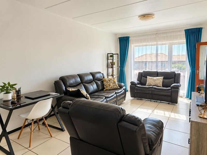 A bright and spacious living room featuring neutral tiled flooring and a large window that allows for ample natural light.