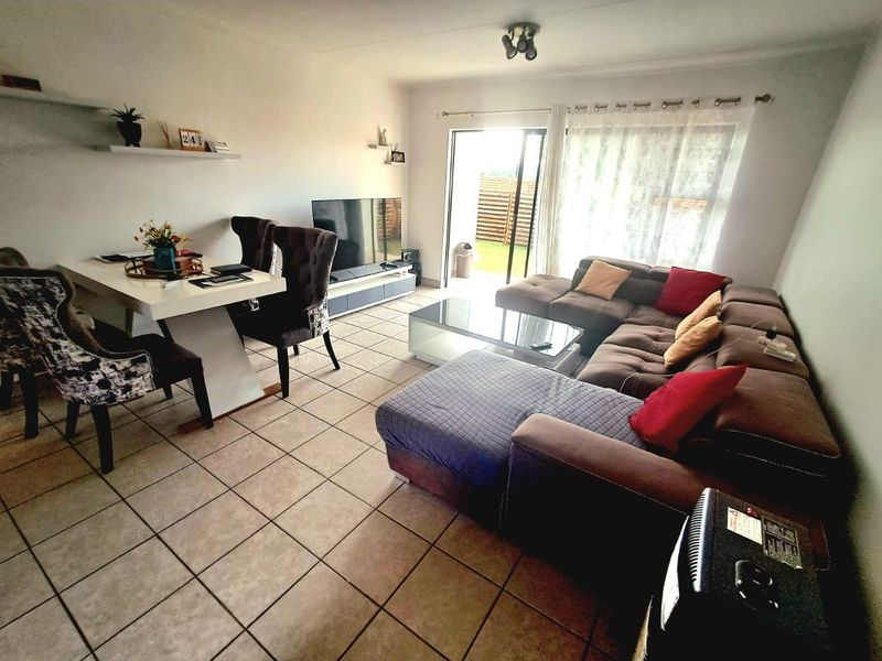 Open-plan living and dining area featuring tiled flooring and a sliding glass door providing access to the outdoor space.